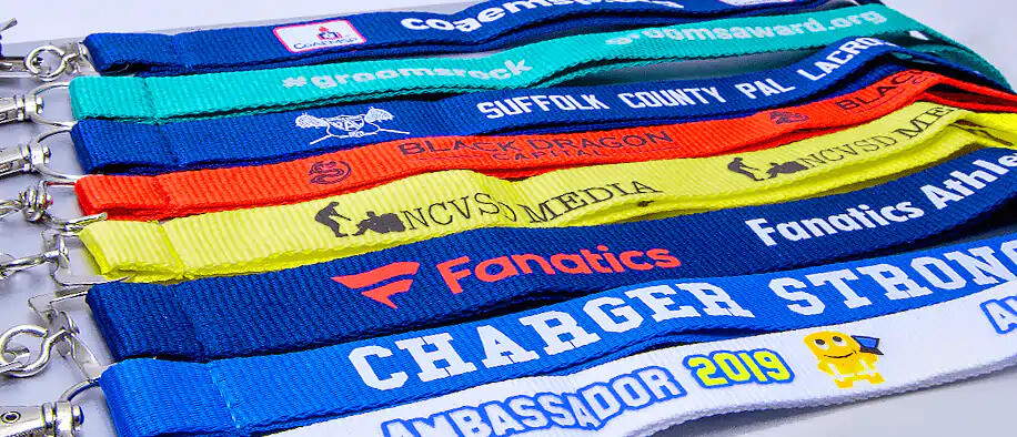Fanned-out polyester lanyards in bright blues, teal, red and yellow, printed with logos and text